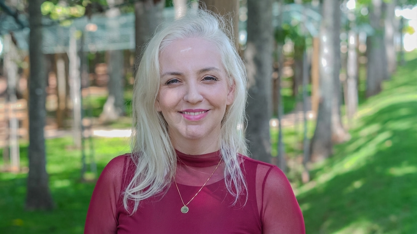 Paula, fundadora do Elos do Éter, sorrindo em meio à natureza
